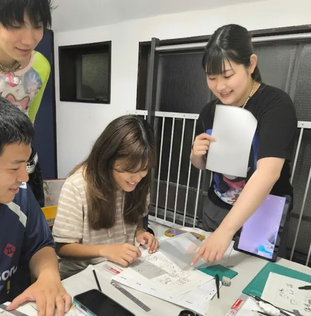 Guests proudly showing their completed manga artwork