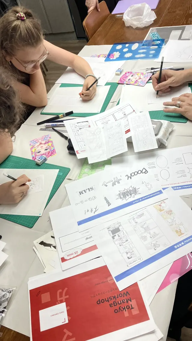 Guest working on their manga story with the Tokyo Manga Workshop folder on the table