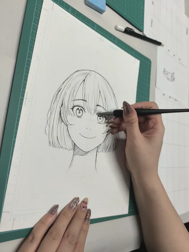 Close-up of hands drawing manga character