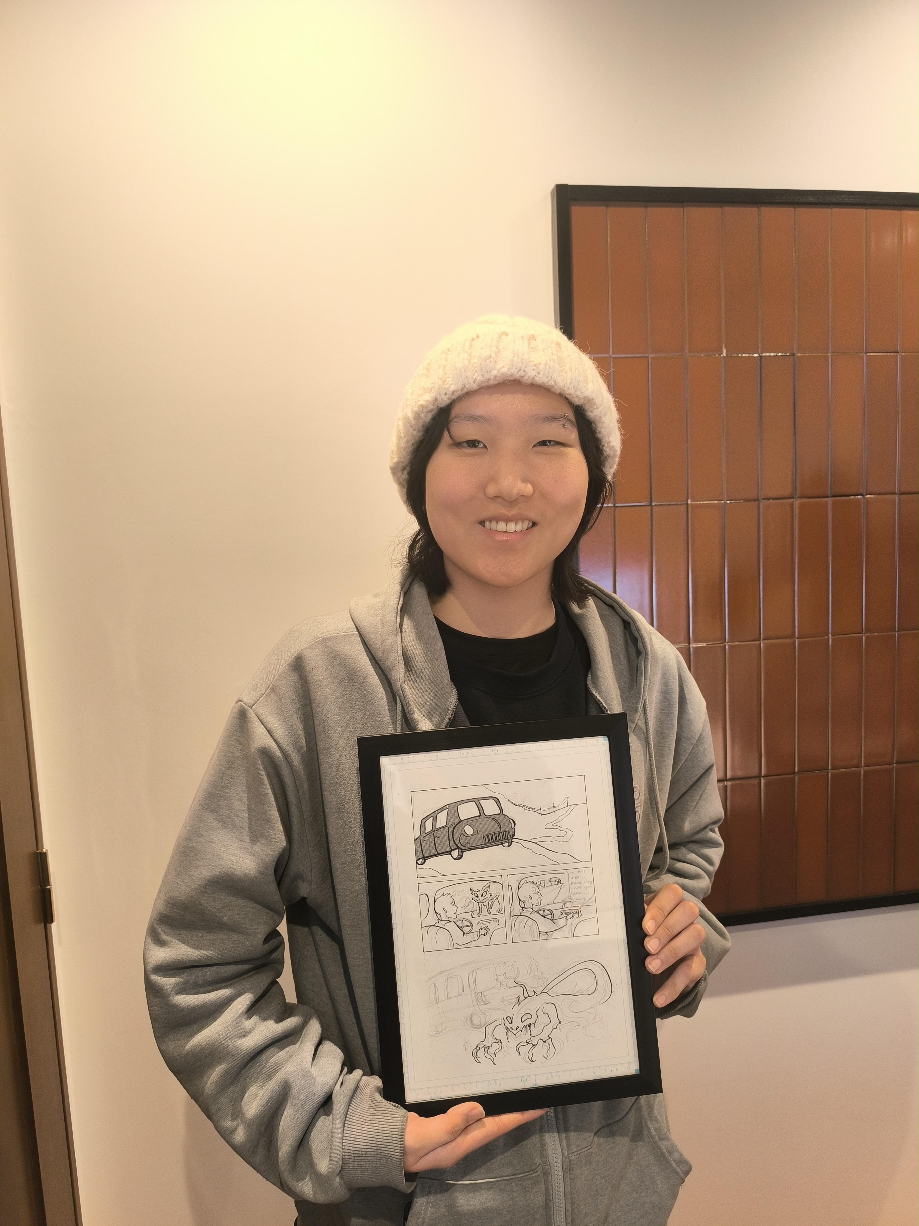 Guest proudly holding framed manga artwork