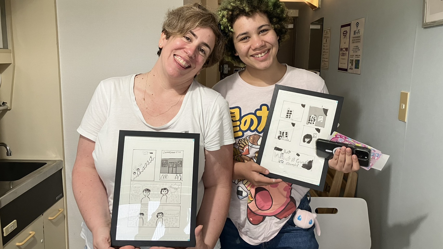 Mother and daughter showing their finished framed manga pages