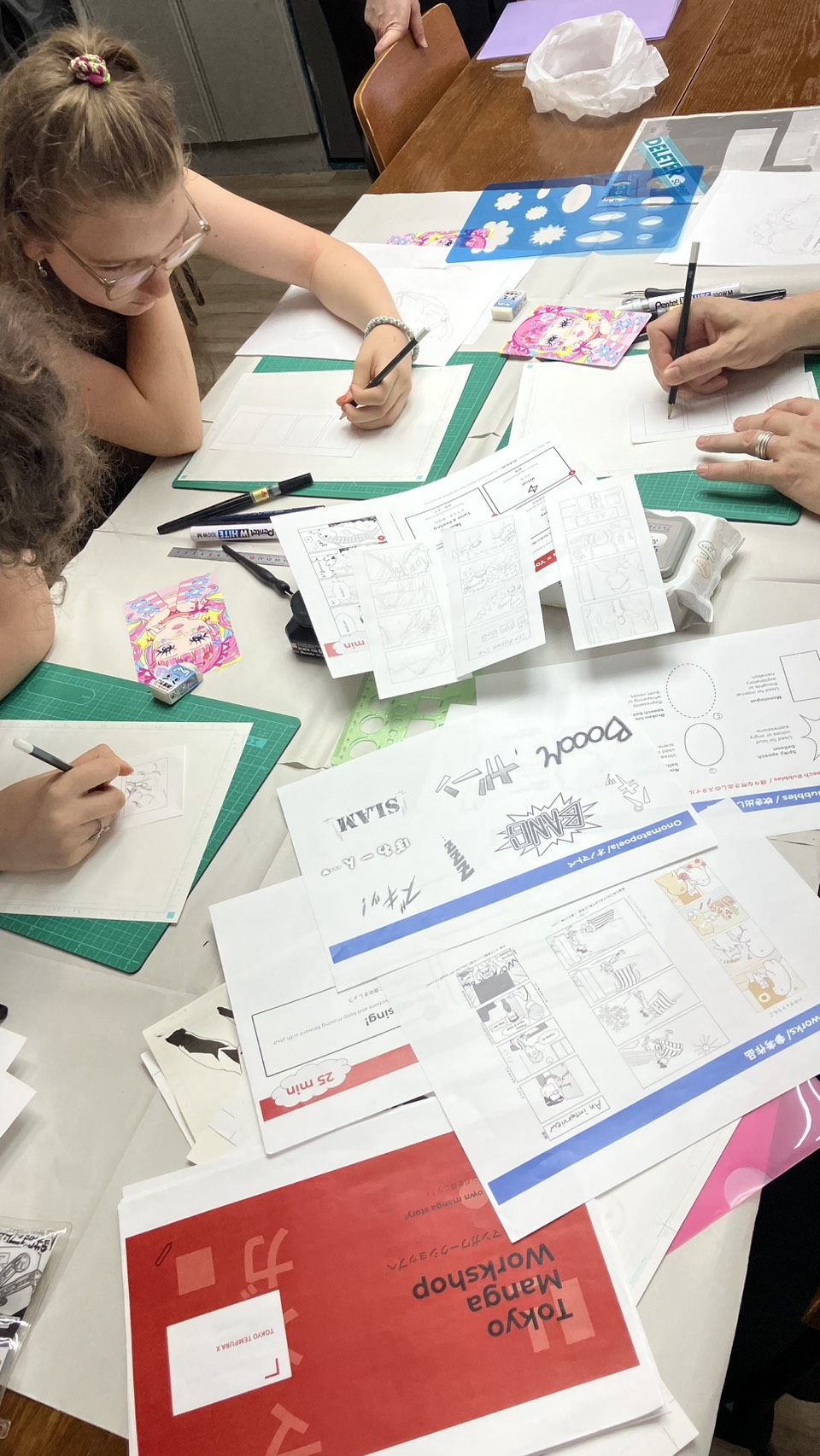 Guest working on their manga story with the Tokyo Manga Workshop folder on the table