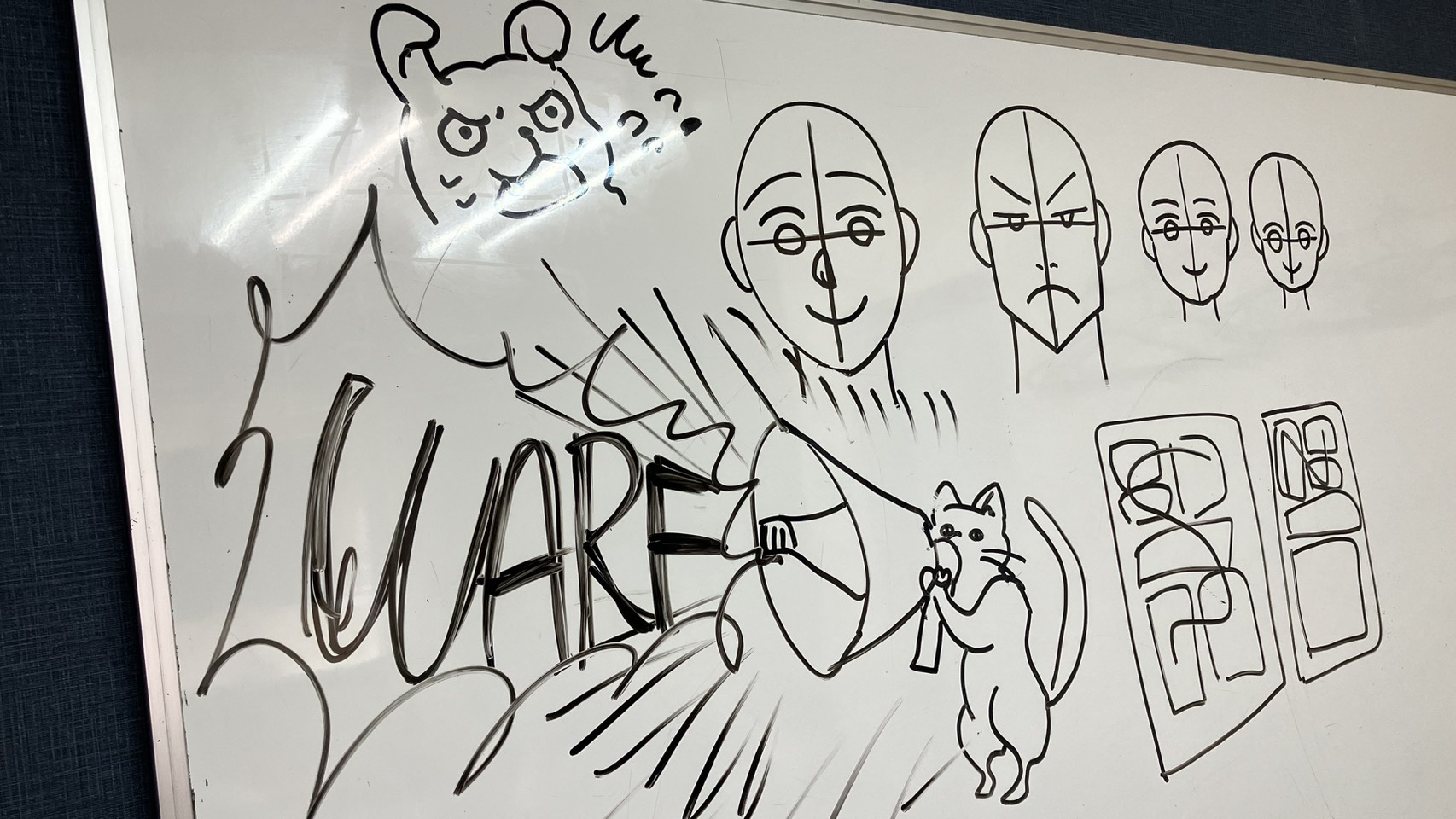 Playful manga character sketch drawn on the studio whiteboard
